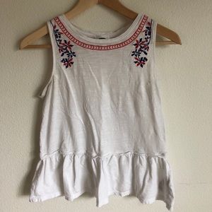 White peplum tank with blue and red detail at neck